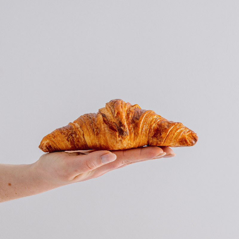 A picture of a croissant on top of a hand